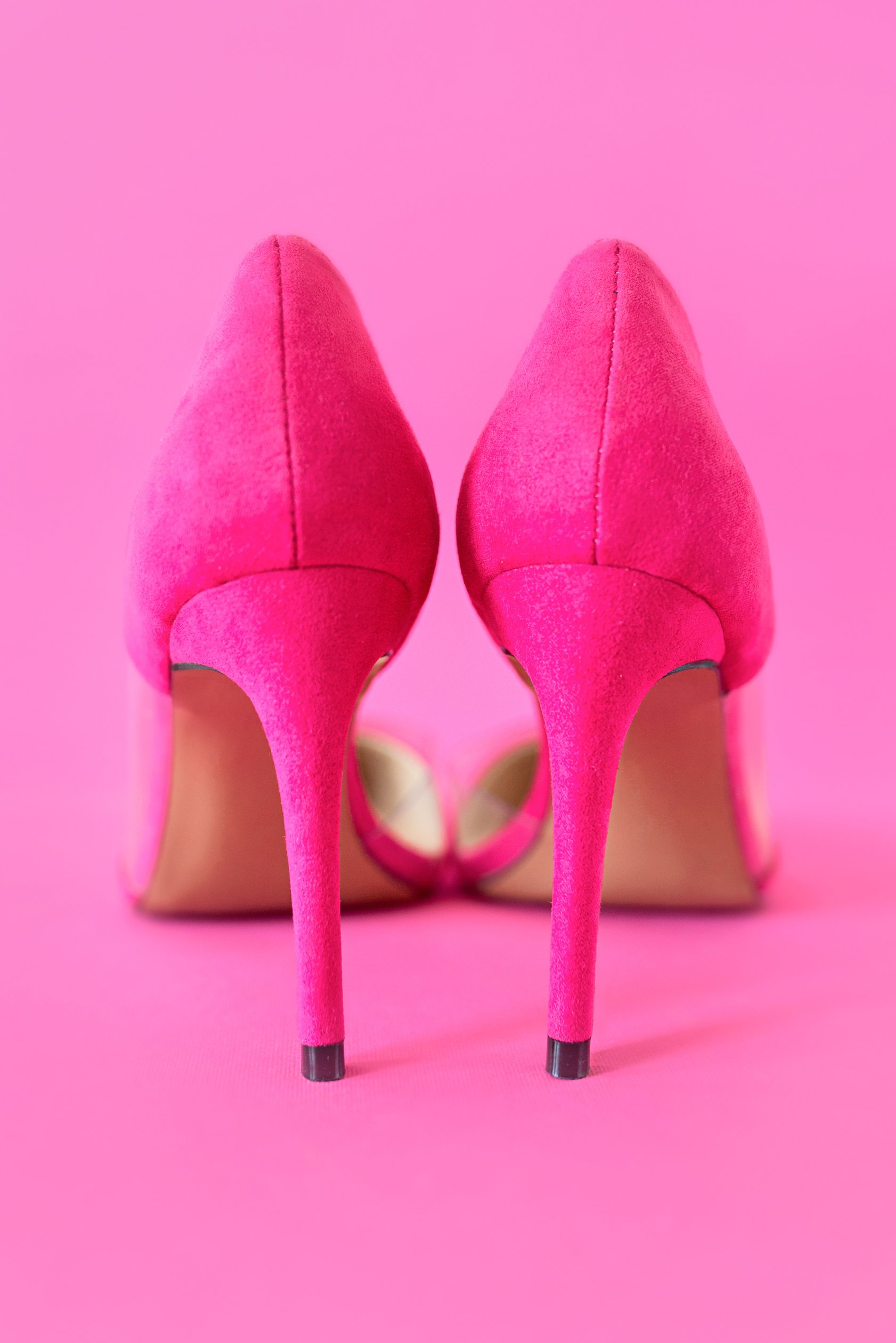 stylish pink high heels shoes on pink background.